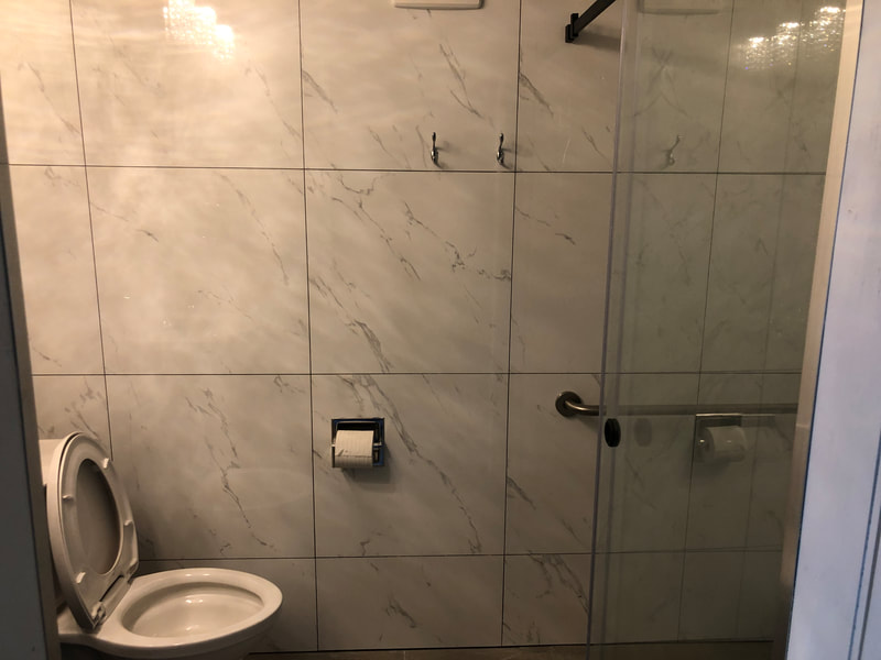 Custom white tile shower with dark grout in Armstrong, BC