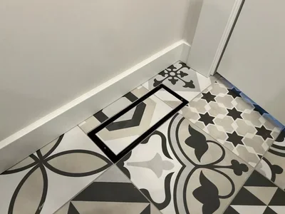 Flush-set floor vent in patterned encaustic tile Installation